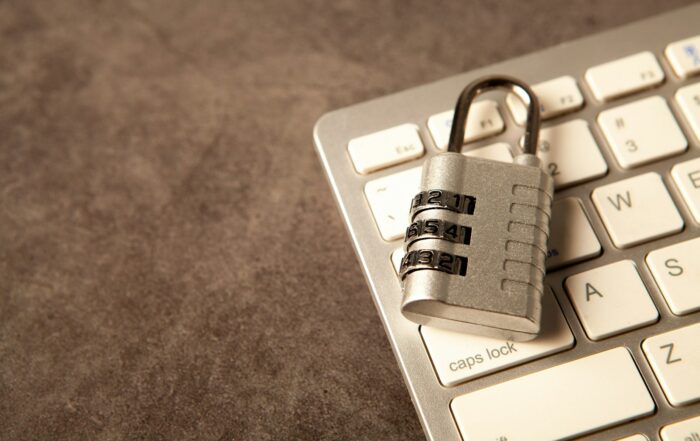Combination padlock resting on a white computer keyboard, representing website and server security