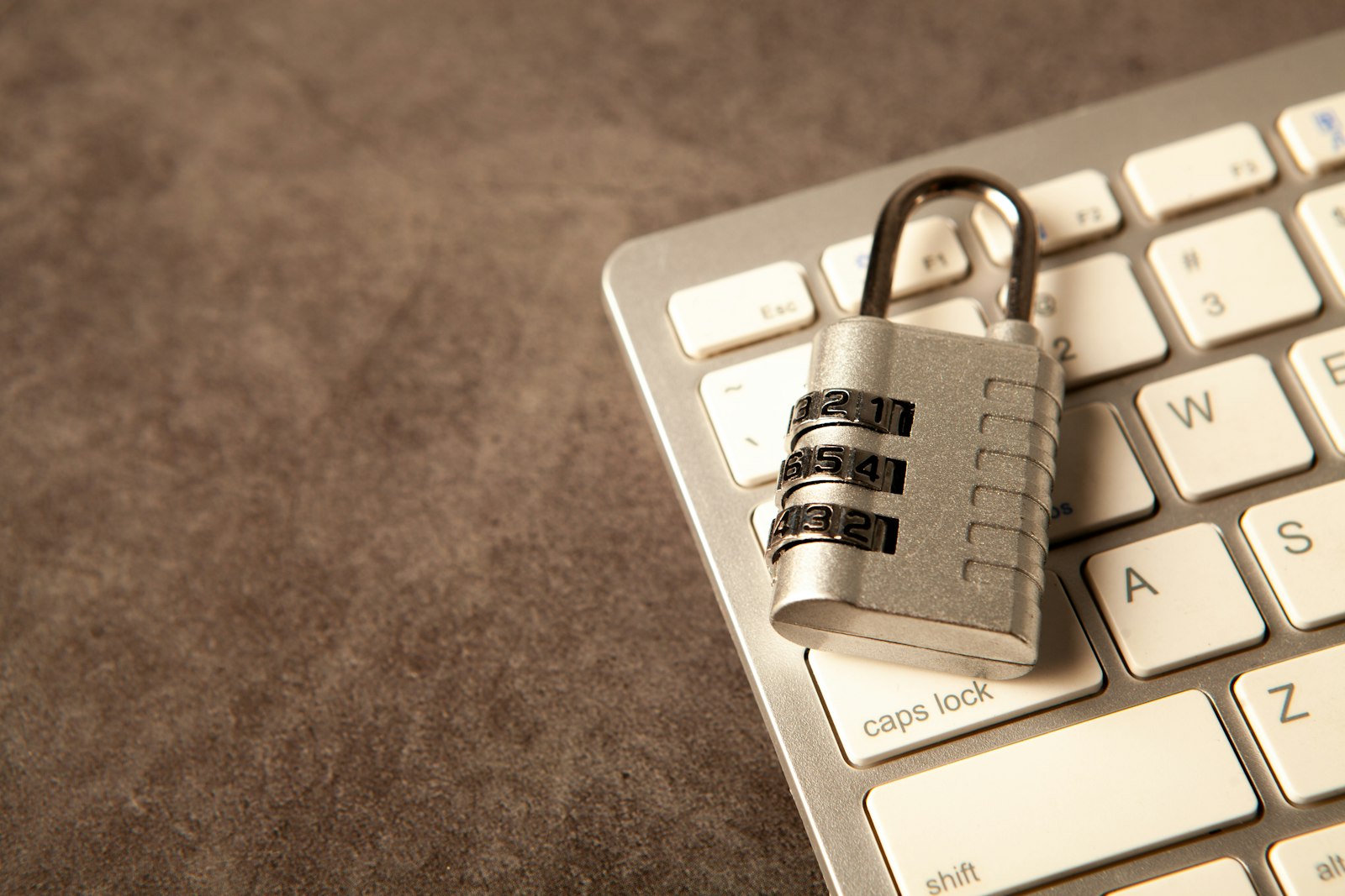 Combination padlock resting on a white computer keyboard, representing website and server security